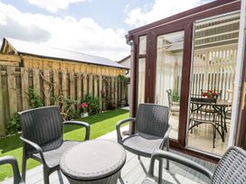 An outdoor seating area with chairs and a table at Dolly Blue Backbarrow near Newby Bridge