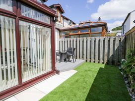 A garden with decking and chairs at Dolly Blue in Backbarrow near Newby Bridge