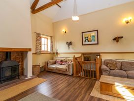 A living room with a fireplace and sofas at Millbarn in Crowcombe