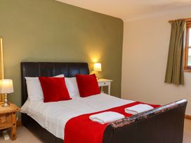 A bedroom with a bed and bedside lamps at Millbarn in Crowcombe