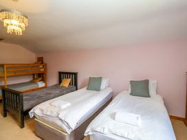 A bedroom with two single beds and a bunk bed at Millbarn in Crowcombe