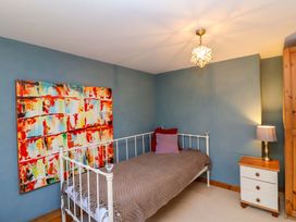 A bedroom with a bed and a bedside table at Millbarn in Crowcombe