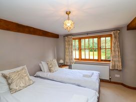 A bedroom with two beds and a window at Millbarn in Crowcombe