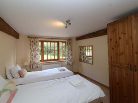 A bedroom with two single beds and a window at Millbarn in Crowcombe
