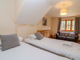 A bedroom with two beds and a sofa at Millbarn in Crowcombe