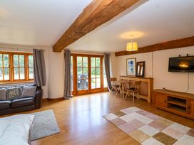 A living room with a sofa and a dining area at Millbarn in Crowcombe