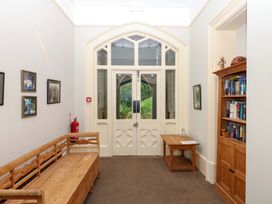 A hallway with a bench, bookshelf, and artwork at 2 Sheplegh Court in Blackawton near Dartmouth