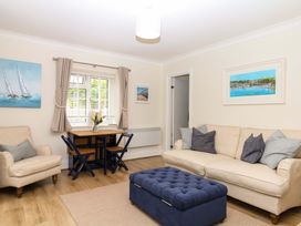 A living room with a sofa, armchair, and dining table at 2 Sheplegh Court in Blackawton near Dartmouth