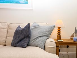 A living room with cushions on a sofa and a lamp on a side table at 2 Sheplegh Court Blackawton near Dartmouth