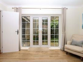 A living room with double doors and a sofa at 2 Sheplegh Court in Blackawton near Dartmouth