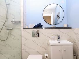 A bathroom featuring a shower, toilet, sink, and mirror at 2 Sheplegh Court Blackawton near Dartmouth