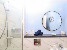 A bathroom featuring a shower, mirror, towels, and sink at 2 Sheplegh Court in Blackawton near Dartmouth