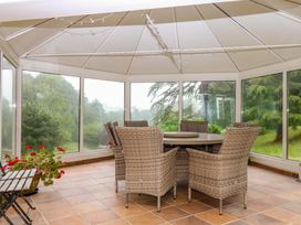 A conservatory with a table and chairs at 2 Sheplegh Court in Blackawton near Dartmouth