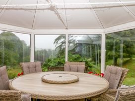 A conservatory with a round table and chairs at 2 Sheplegh Court Blackawton near Dartmouth