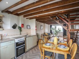 A kitchen with dining table and sofa at Fadrun - 3 Ty'n Don