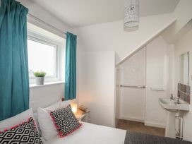 A bedroom with a bed and washbasin at Fadrun - 3 Ty'n Don