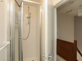 A shower enclosure with a door and handrail at Fadrun - 3 Ty'n Don