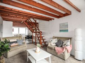 A living room with sofas and a staircase at Penrhyn - 4 Ty'n Don