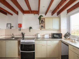 A kitchen with appliances and cabinets at Penrhyn - 4 Ty'n Don