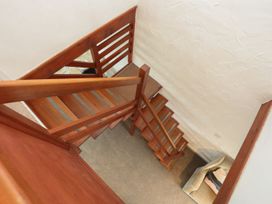 A staircase with wooden railing and carpet at Penrhyn - 4 Ty'n Don