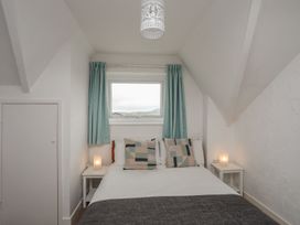A bedroom with a bed and window at Penrhyn - 4 Ty'n Don