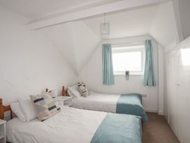 A bedroom with two beds and a window at Penrhyn - 4 Ty'n Don