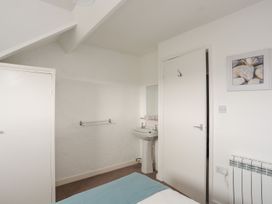 A bathroom with a sink and a mirror at Penrhyn - 4 Ty'n Don