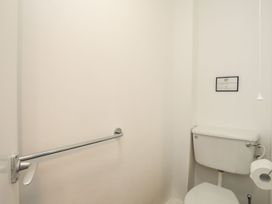 A bathroom with a toilet and grab bar at Penrhyn - 4 Ty'n Don 