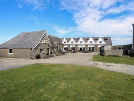 An outdoor area with buildings and seating at Penrhyn - 4 Ty'n Don, 