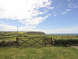 A view of a gate and wind turbine overlooking the sea at Penrhyn - 4 Ty'n Don