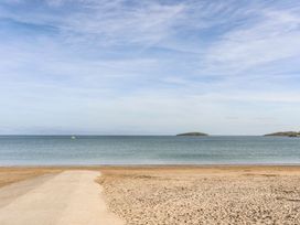 A beach with sand and water at Penrhyn - 4 Ty'n Don