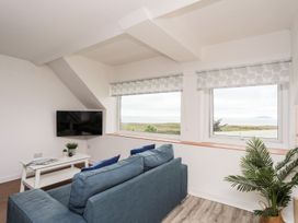 A living room with a sofa and television at Towyn - 7 Ty'n Don