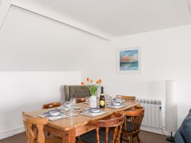A dining room with a wooden table set for dining at Towyn - 7 Ty'n Don