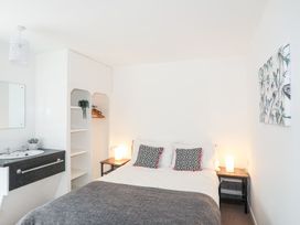 A bedroom with a bed, sink, and shelves at Towyn - 7 Ty'n Don