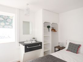 A bedroom with a bed and sink at Towyn - 7 Ty'n Don