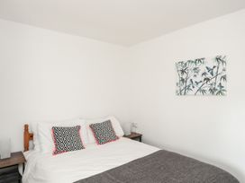 A bedroom with a bed and wall art at Towyn - 7 Ty'n Don