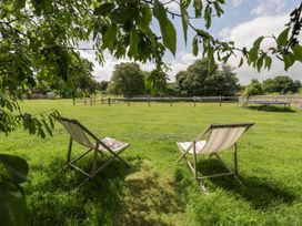 A garden with two chairs and a view of the grass at The End in Langport