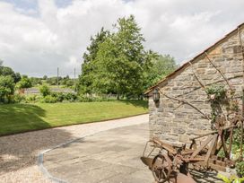 An outdoor area with a stone wall and rusty equipment at The End in Langport