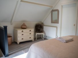 A bedroom with a dresser and mirror at The End in Low Ham near Langport