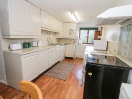 A kitchen with cabinets and appliances including a sink and refrigerator at The Old Post Office in null