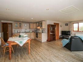 A kitchen and living area with dining table and sofa at Bluebell Cottage