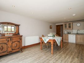 A kitchen with a dining table and sideboard at Bluebell Cottage