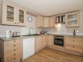 A kitchen with cabinets, sink, and appliances at Bluebell Cottage