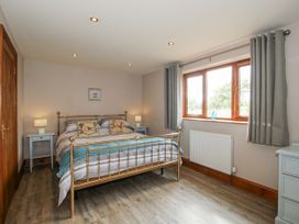 A bedroom with a bed and nightstands at Bluebell Cottage