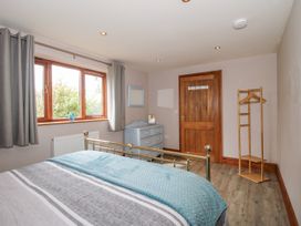 A bedroom with a double bed and dresser at Bluebell Cottage