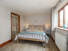A bedroom with a bed and window at Bluebell Cottage