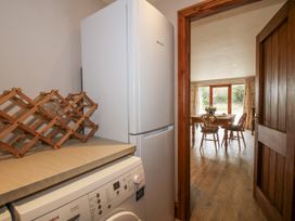 A kitchen with a refrigerator and washing machine at Bluebell Cottage 