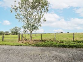 A tree and fence in a grassy field at Bluebell Cottage 