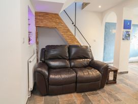 A living room with a sofa and staircase at Lenny's Place in Watchet