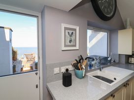 A kitchen with a view of the sea and utensils at Lenny's Place in Watchet